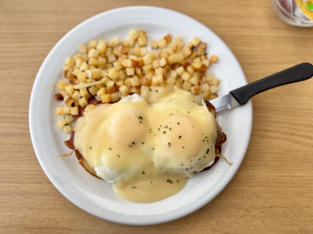 Craig’s Benedict breakfast at Craig’s Way Station in Canmore, Alberta, featuring poached eggs topped with rich hollandaise sauce, served with crispy hash browns. A classic Canadian brunch dish perfect for fueling up before exploring the Rockies.