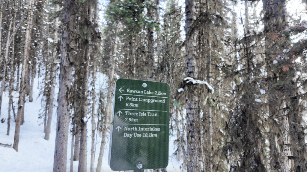 A sign show turning left to Rawson Lake and continue the trail to Point Campground, Three Isle Trail and North Interlakes Day Use