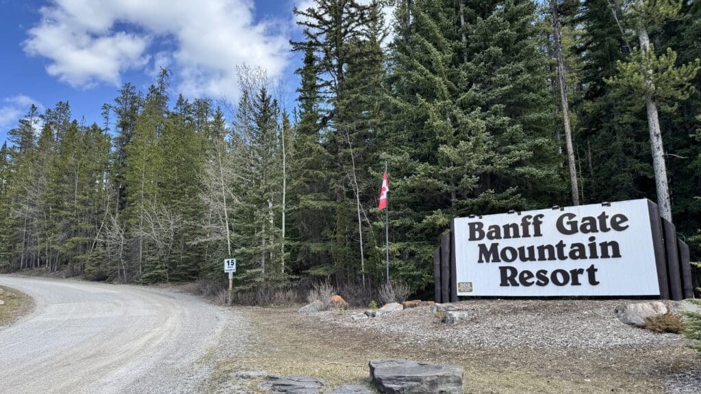 A big Banff Gate Mountain Resort sign on road in Dead Man's Flats in Kananaskis Country