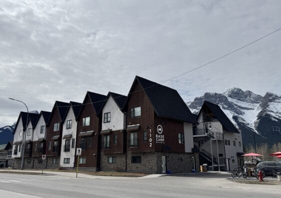 Exterior view of Basecamp Lodge Canmore with rustic alpine-style architecture, nestled beneath the Rocky Mountains in downtown Canmore