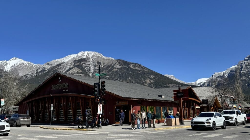 Exterior view of Stonewaters Home Elements store in downtown Canmore, Alberta, with snow-capped mountains in the background and people browsing outside the shop on a sunny day