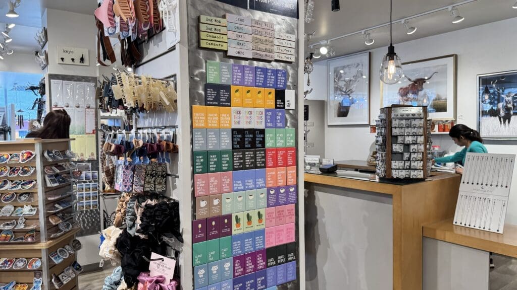 Colorful and eclectic interior of The Tin Box gift shop in Canmore, Alberta, featuring trendy accessories, quirky magnets, handmade jewelry, and unique Canadian souvenirs.