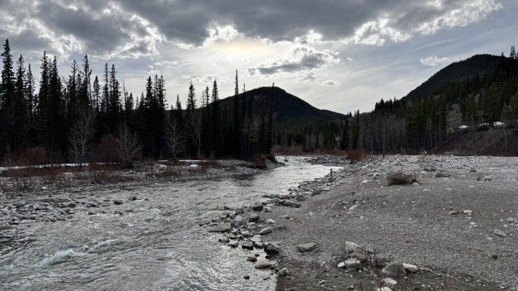 Elbow River along Highway 66 near Bragg Creek in Alberta Canada flowing through a rocky riverbed with surrounding pine forest and mountain foothills in Kananaskis Country