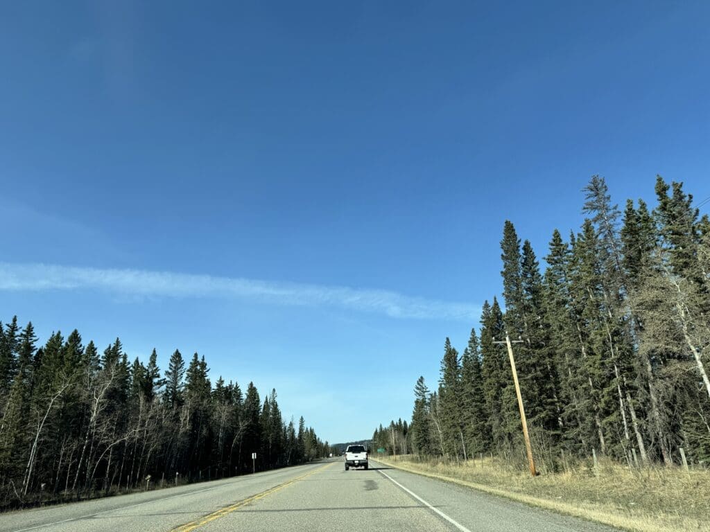 Scenic drive on Alberta Highway 66 to Prairie Mountain near Bragg Creek, Canada – pine forest landscape, clear skies, and popular hiking route in Kananaskis Country